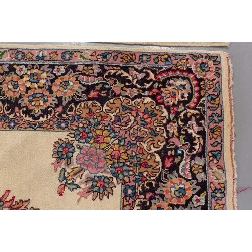 177 - A pair of ivory ground Kerman rugs with central floral medalion and corresponding corners. 128 cm x ... 