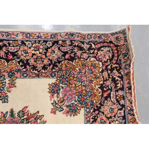 177 - A pair of ivory ground Kerman rugs with central floral medalion and corresponding corners. 128 cm x ... 