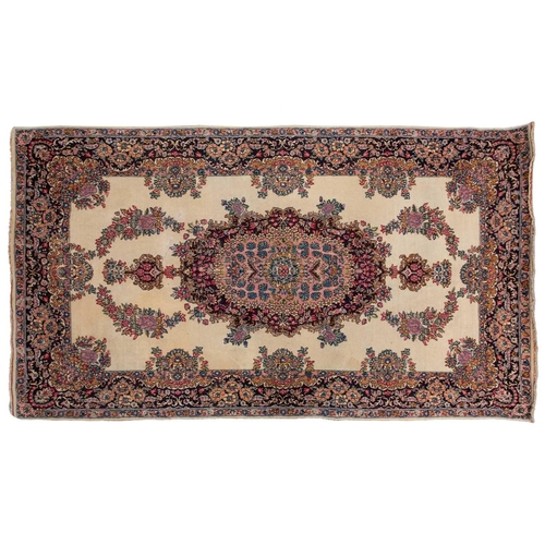 177 - A pair of ivory ground Kerman rugs with central floral medalion and corresponding corners. 128 cm x ... 