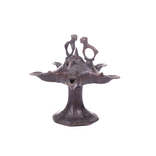 193 - A Bactrian-style oil lamp, with five spouts around a central hinged lid and two mythical beast termi... 