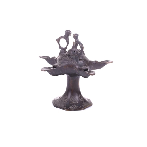 193 - A Bactrian-style oil lamp, with five spouts around a central hinged lid and two mythical beast termi... 