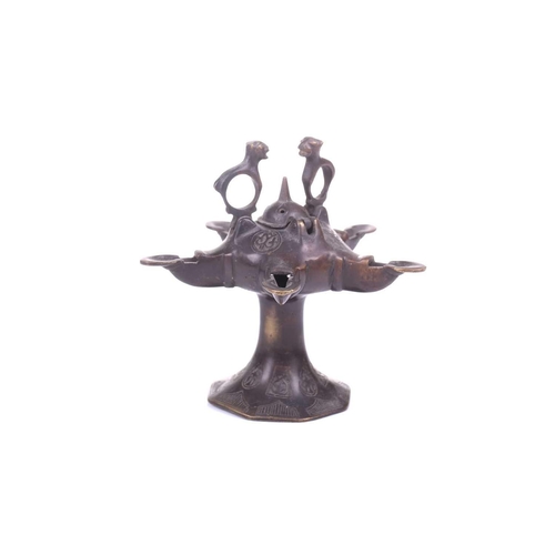 193 - A Bactrian-style oil lamp, with five spouts around a central hinged lid and two mythical beast termi... 