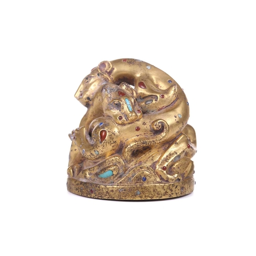 194 - A Chinese gilt bronze Tang-style fighting tiger scroll weight set with polished hardstones, with an ... 