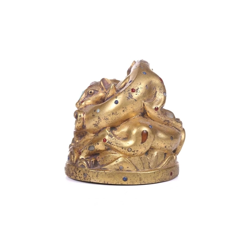 194 - A Chinese gilt bronze Tang-style fighting tiger scroll weight set with polished hardstones, with an ... 