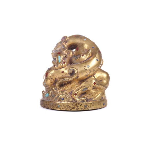 194 - A Chinese gilt bronze Tang-style fighting tiger scroll weight set with polished hardstones, with an ... 