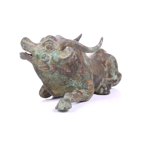 202 - A Chinese bronze and gilt recumbent bull, possibly Zhou dynasty or later, the animal with one leg ou... 