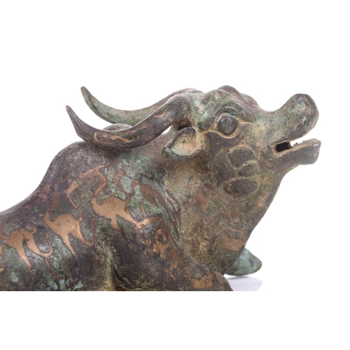 202 - A Chinese bronze and gilt recumbent bull, possibly Zhou dynasty or later, the animal with one leg ou... 