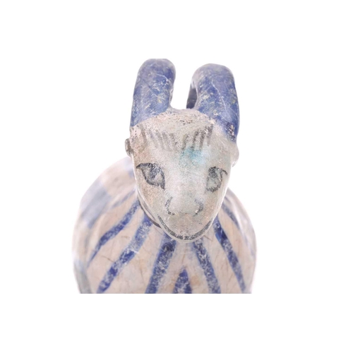 231 - An Islamic pottery ram, probably Iran, the cylindrical body decorated with bands of black and blue, ... 