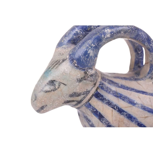 231 - An Islamic pottery ram, probably Iran, the cylindrical body decorated with bands of black and blue, ... 