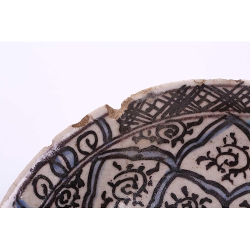 240 - An Islamic faience charger, 17th/18th century, decorated with repeating motifs, within blue and blac... 