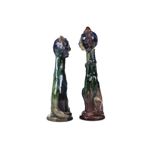 244 - A pair of earthenware winking cat candlesticks, in blue and green glaze, one with impressed 5 under ... 