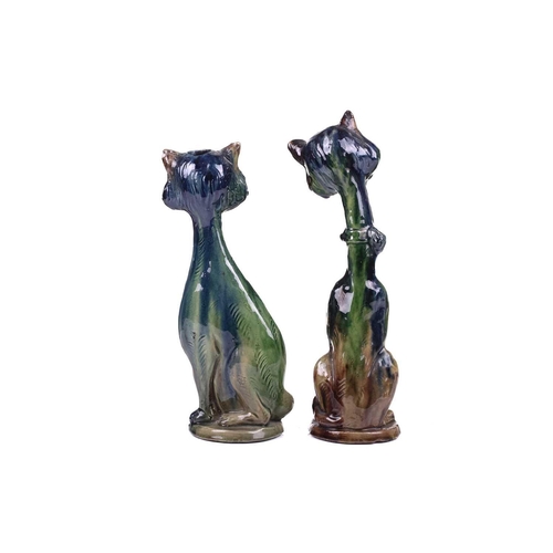 244 - A pair of earthenware winking cat candlesticks, in blue and green glaze, one with impressed 5 under ... 