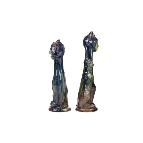 244 - A pair of earthenware winking cat candlesticks, in blue and green glaze, one with impressed 5 under ... 