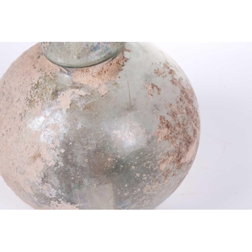 250 - A Roman glass bulbous flask with everted rim, signs of oxidation and encrusted soil to the iridescen... 