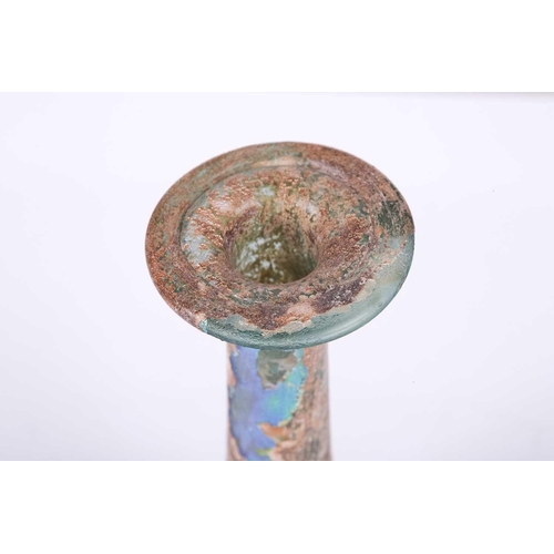 256 - A Roman glass Unguentarium flask with rolled everted rim and stepped conical body, with an extensive... 