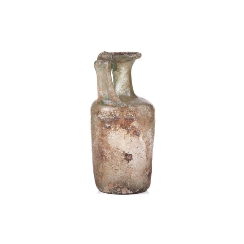 261 - A Roman glass oil ewer of slightly perpendicular form with moulded strap handle to the everted rim, ... 