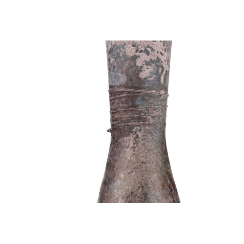 262 - A Roman glass inverted baluster flask with a slightly flared mouth with a band of trailed decoration... 