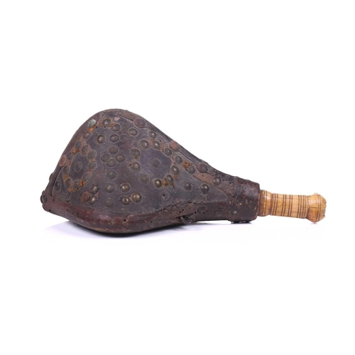 274 - A North African triangular section powder flask 18th/19th century, with studded hide body and turned... 