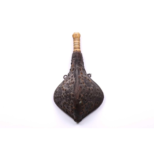 274 - A North African triangular section powder flask 18th/19th century, with studded hide body and turned... 