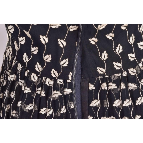 103 - Christian Dior; a black and embroidered long dress, with long sleeves and high neckline, 'Boutique' ... 