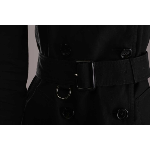 105 - Burberry - a 'Kensington' trench coat in black, lined with Burberry check pattern, double-breasted b... 