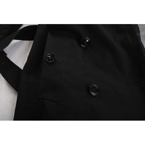 105 - Burberry - a 'Kensington' trench coat in black, lined with Burberry check pattern, double-breasted b... 
