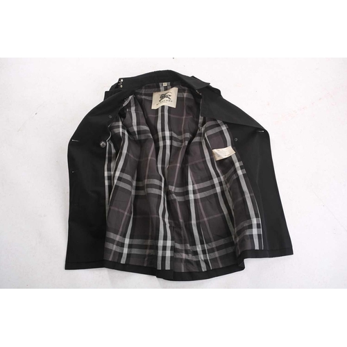105 - Burberry - a 'Kensington' trench coat in black, lined with Burberry check pattern, double-breasted b... 