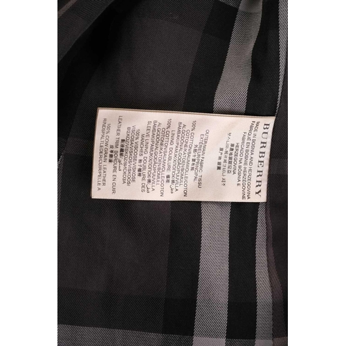 105 - Burberry - a 'Kensington' trench coat in black, lined with Burberry check pattern, double-breasted b... 