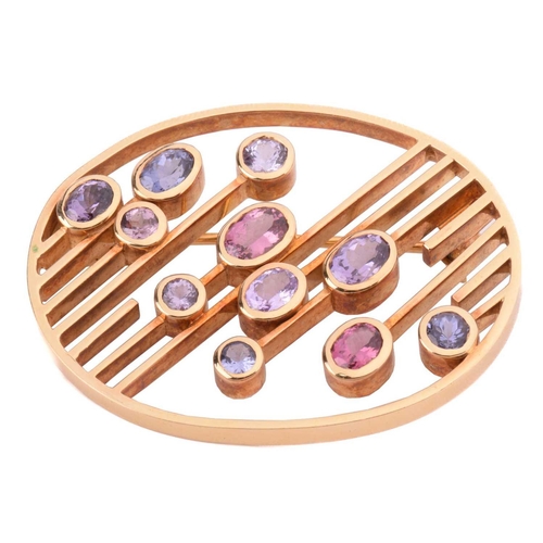 100 - A modernist oval spinel brooch, set with various colour spinels ranging from pink to mauve and blue,... 