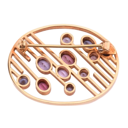 100 - A modernist oval spinel brooch, set with various colour spinels ranging from pink to mauve and blue,... 