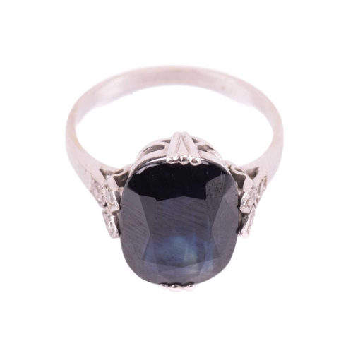 105 - A sapphire solitaire ring features a cushion-cut sapphire of dark blue colour, approximately measure... 