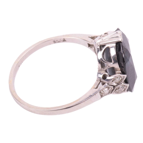 105 - A sapphire solitaire ring features a cushion-cut sapphire of dark blue colour, approximately measure... 