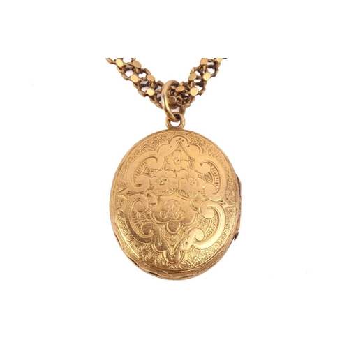 108 - An oval locket with a cross motif and engraved floral decoration, measuring 27 x 23mm, with a tubula... 