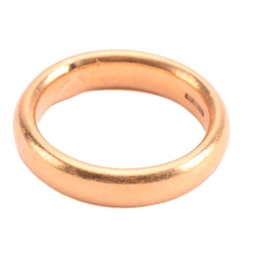 111 - A wedding ring in 22ct yellow gold, constructed by a court-profile plain band, London hallmarked '22... 