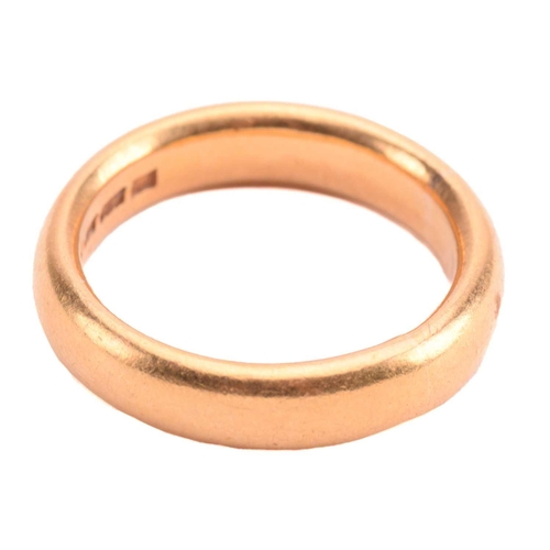 111 - A wedding ring in 22ct yellow gold, constructed by a court-profile plain band, London hallmarked '22... 