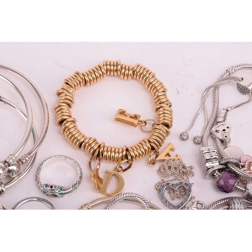 128 - A collection of branded jewellery comprising ten Pandora bangles some with charms, a Thomas Sabo sna... 