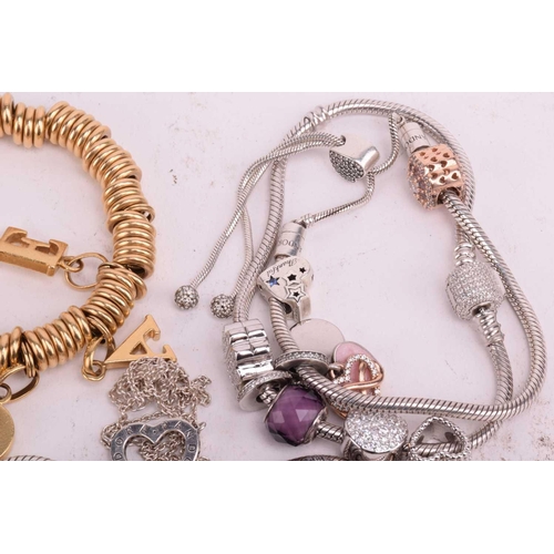 128 - A collection of branded jewellery comprising ten Pandora bangles some with charms, a Thomas Sabo sna... 