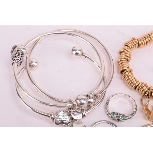 128 - A collection of branded jewellery comprising ten Pandora bangles some with charms, a Thomas Sabo sna... 