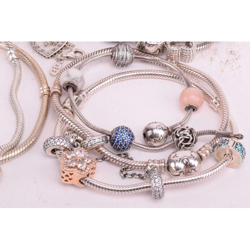 128 - A collection of branded jewellery comprising ten Pandora bangles some with charms, a Thomas Sabo sna... 