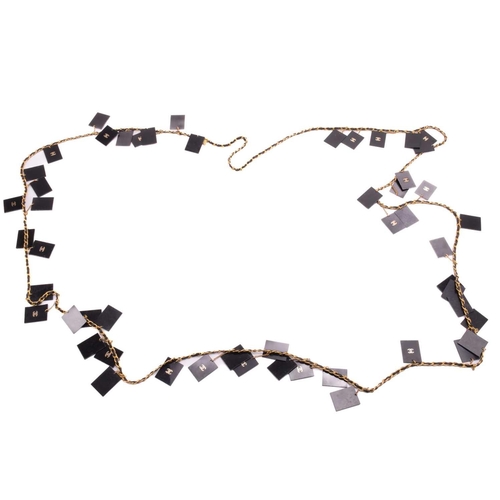 129 - Chanel - two bangles and a necklace; the first is a 1992 padded black leather bangle, dangling with ... 