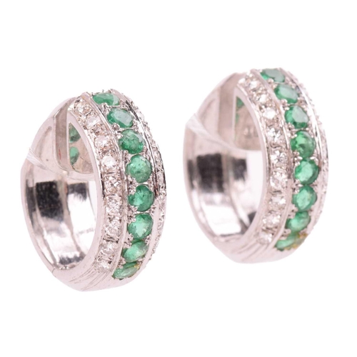 132 - A pair of emerald and diamond 'huggy' hoop earrings, both set with a central row of round cut emeral... 