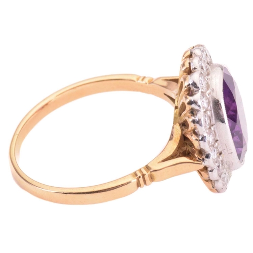 152 - An amethyst and diamond halo ring, featuring an oval-cut amethyst of 11.7 x 9.8 x 5.8 mm, collet-set... 