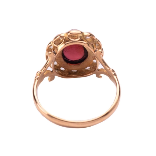 155 - A garnet and rose diamond cluster ring, centred with an oval garnet hollow cabochon in a millgraine ... 