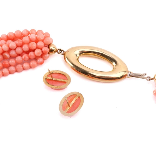 159 - A pink coral torsade necklace and earrings en-suite; the necklace contains nine rows of pink coral b... 