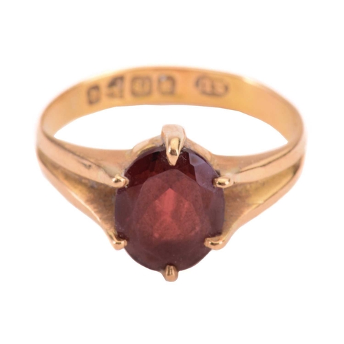 165 - A garnet single stone ring, the almandine garnet measuring 10 x 7.9mm, in a claw setting, the shank ... 