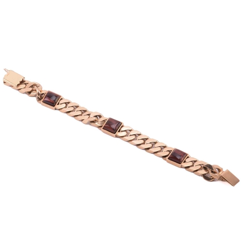 172 - A heavy curb link bracelet in 9ct yellow gold, with three square buffed-top red tiger's eye spacers,... 