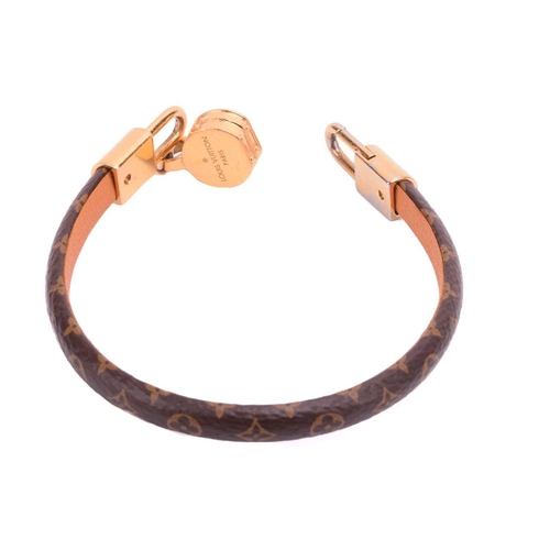 181 - Louis Vuitton - a 'Tribute' bracelet, comprising a monogram canvas strap with leather lining, dangli... 