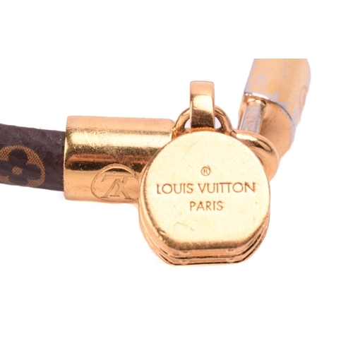 181 - Louis Vuitton - a 'Tribute' bracelet, comprising a monogram canvas strap with leather lining, dangli... 