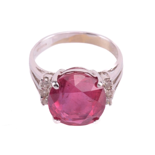 183 - A ruby and diamond ring, the four-claw set oval cut ruby approximately 12.5mm x 11.5mm, the trifurca... 