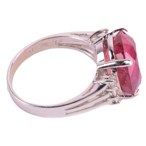 183 - A ruby and diamond ring, the four-claw set oval cut ruby approximately 12.5mm x 11.5mm, the trifurca... 